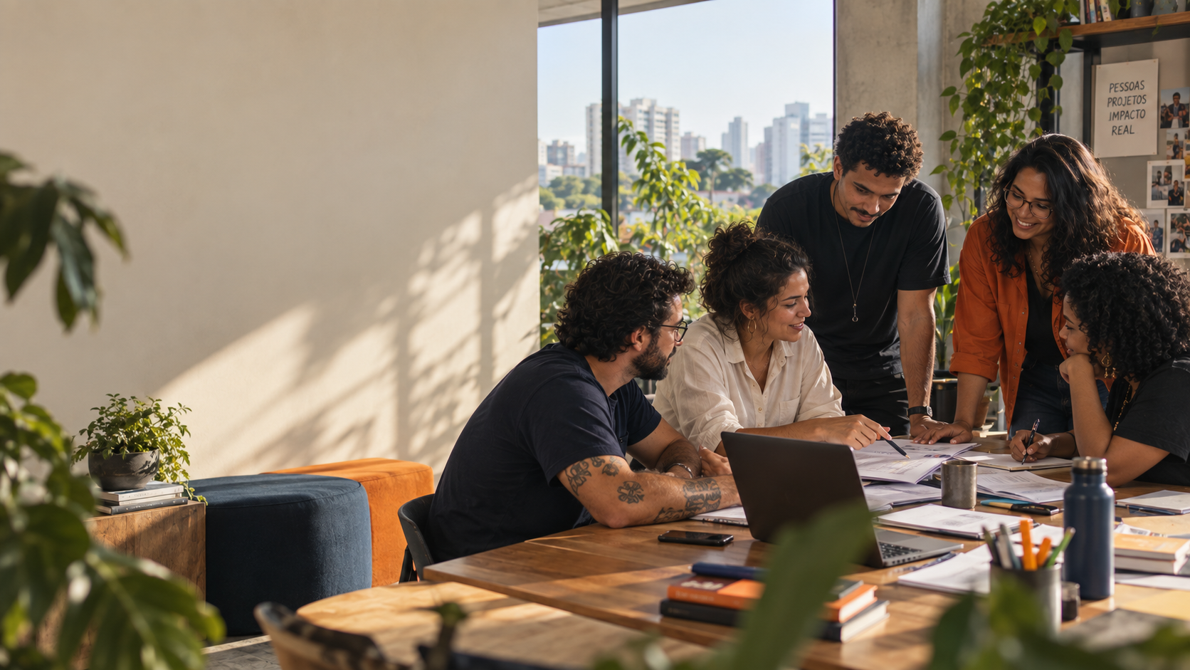 Equipe de uma organização social reunida em volta de uma mesa de trabalho, colaborando em projetos